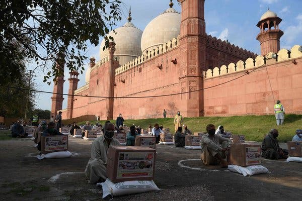 People followed social distancing rules after being given food at a Lahore mosque on Tuesday.